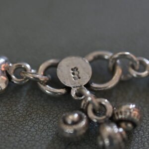 Close-up of a silver heart-link anklet showing clasp and intricate chain details
