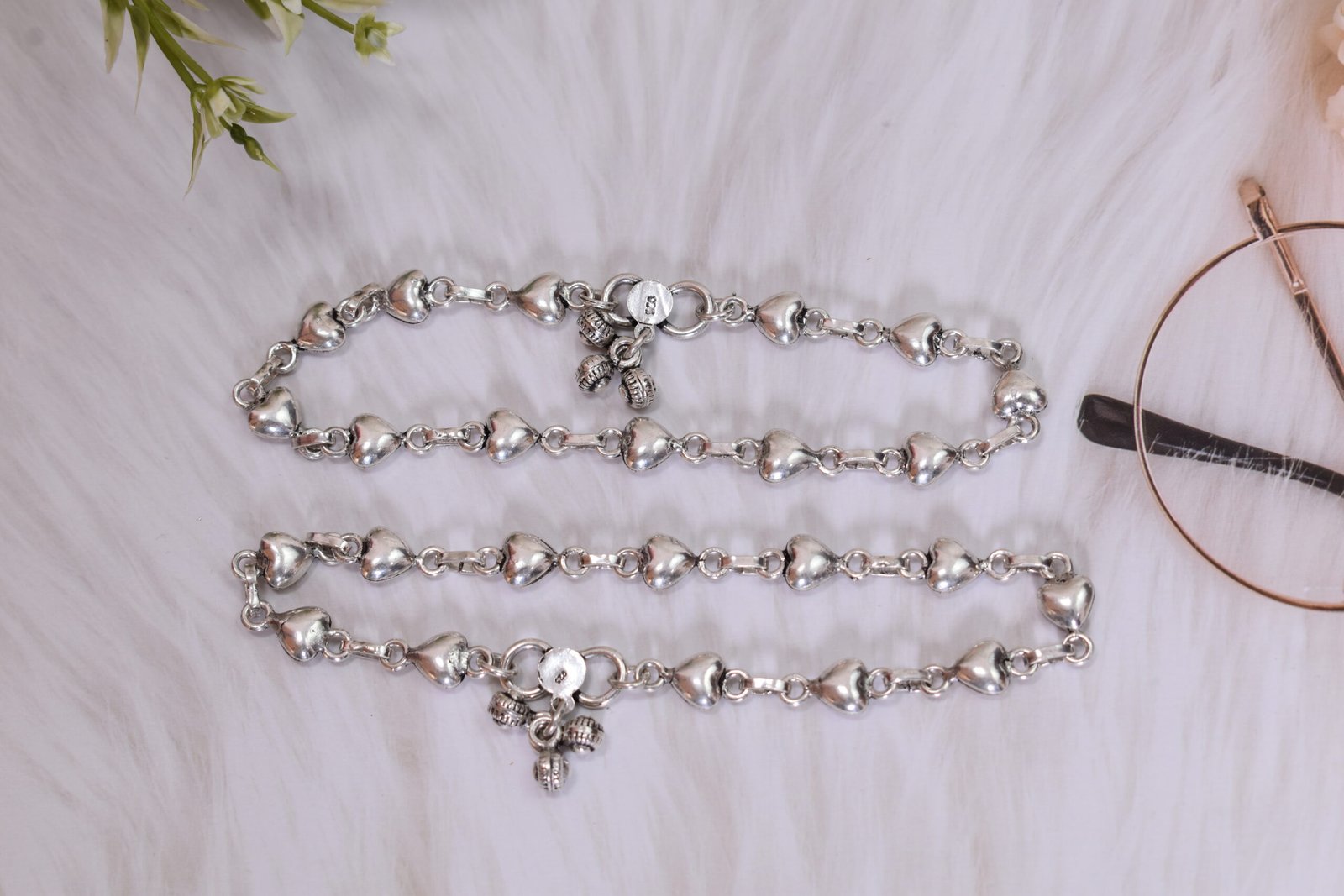 Silver Heart Link Anklet | Sukhambika 925 Atelier Delicate silver heart-link anklet arranged on a blue background with floral accents
