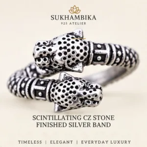 Main promotional product image of the classic lion face chitai silver band (erroneously labelled as scintillating cz stone finished silver band in the source image) resting on a textured white stone surface, highlighting the text "Timeless | Elegant | Everyday Luxury".