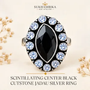 Main promotional product image of the scintillating center black cutstone jadau silver ring resting on a textured white surface, highlighting the bold black marquise stone and classic jadau design.