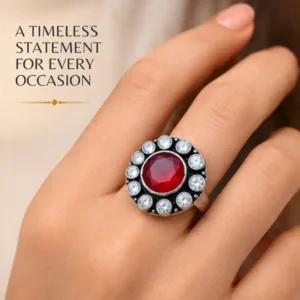 Close-up lifestyle portrait of a woman's hand wearing the scintillating center round ruby cutstone jadau silver ring, featuring text highlighting a timeless statement for every occasion.