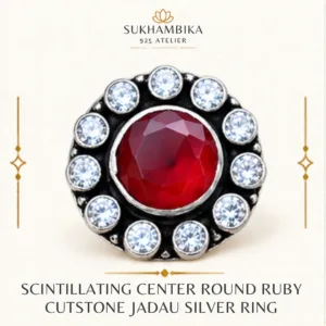 Main promotional product image of the scintillating center round ruby cutstone jadau silver ring resting on a textured white stone surface, highlighting the vibrant ruby stone and classic jadau design.