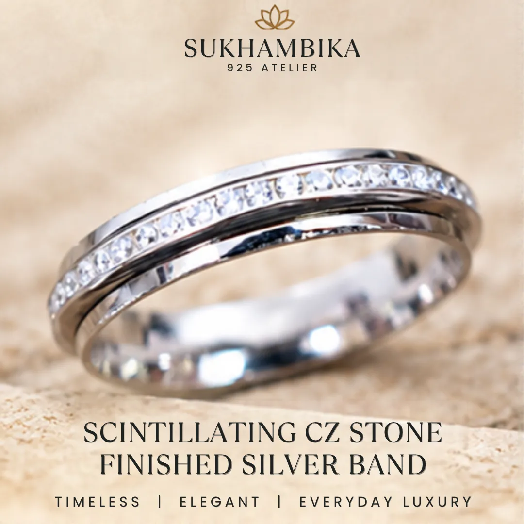 scintillating-cz-stone-finished-silver-band-sukhambika Main promotional product image of the scintillating cz stone finished silver band resting on a textured white stone surface, highlighting the text "Timeless | Elegant | Everyday Luxury".